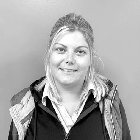 A black and white photo of Jenny, a blonde woman wearing a Lowdhams employee uniform