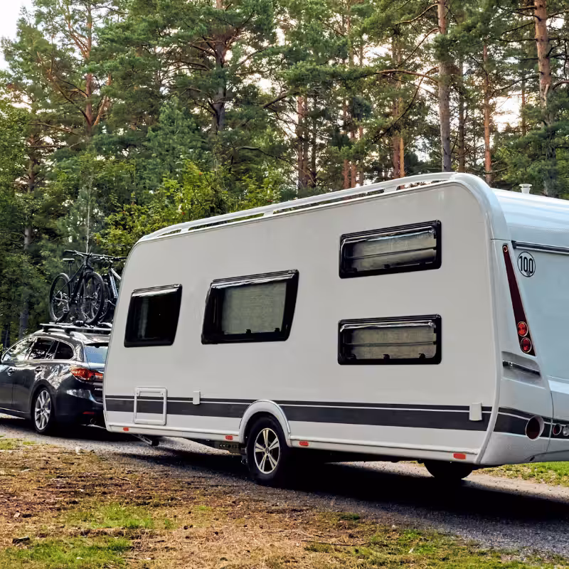 A car pulling a white caravan