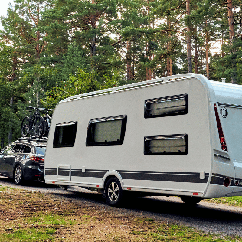 A car pulling a white caravan
